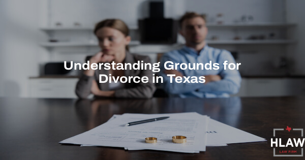 Divorced couple seated apart, with divorce papers and wedding rings on a table, symbolizing no-fault divorce in Texas, related to legal guidance from HLAW.