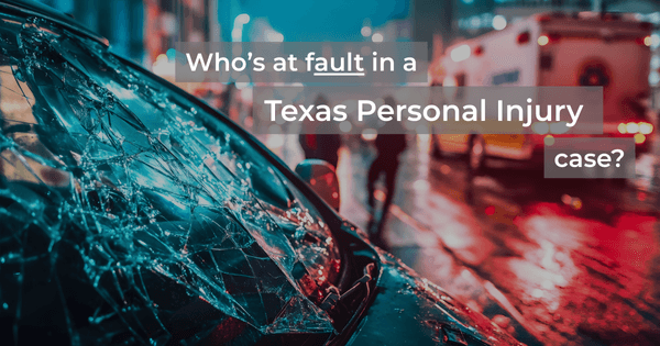 Shattered car windshield on a city street at night with ambulance and pedestrians in the background, illustrating fault in a Texas personal injury case.