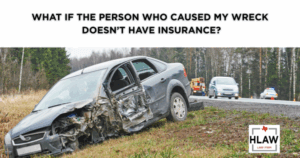 A severely damaged car on the side of a road, illustrating a blog post about what to do after a car wreck with an uninsured driver in Texas.