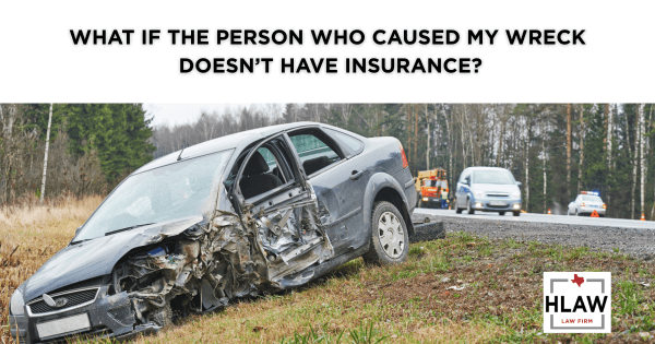 A severely damaged car on the side of a road, illustrating a blog post about what to do after a car wreck with an uninsured driver in Texas.